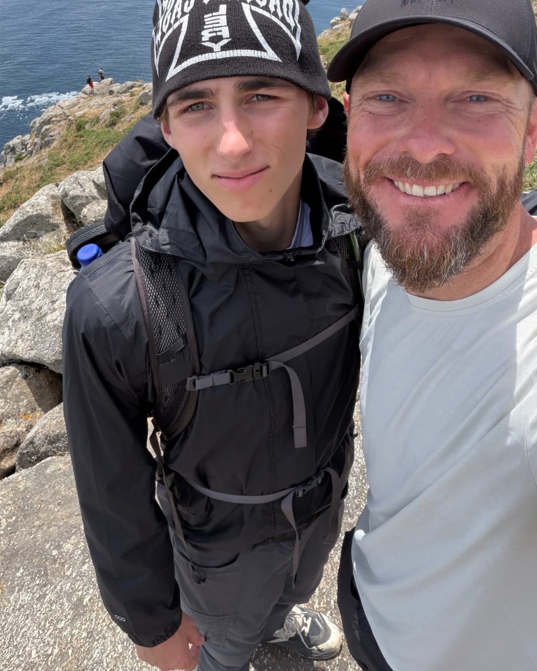 Jake Hamilton and his son at the end of the Camino, with the Atlantic behind them